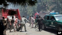 Afghans carry an injured man after a suicide car bombing in Helmand province southern of Kabul, Afghanistan, June 22, 2017. 