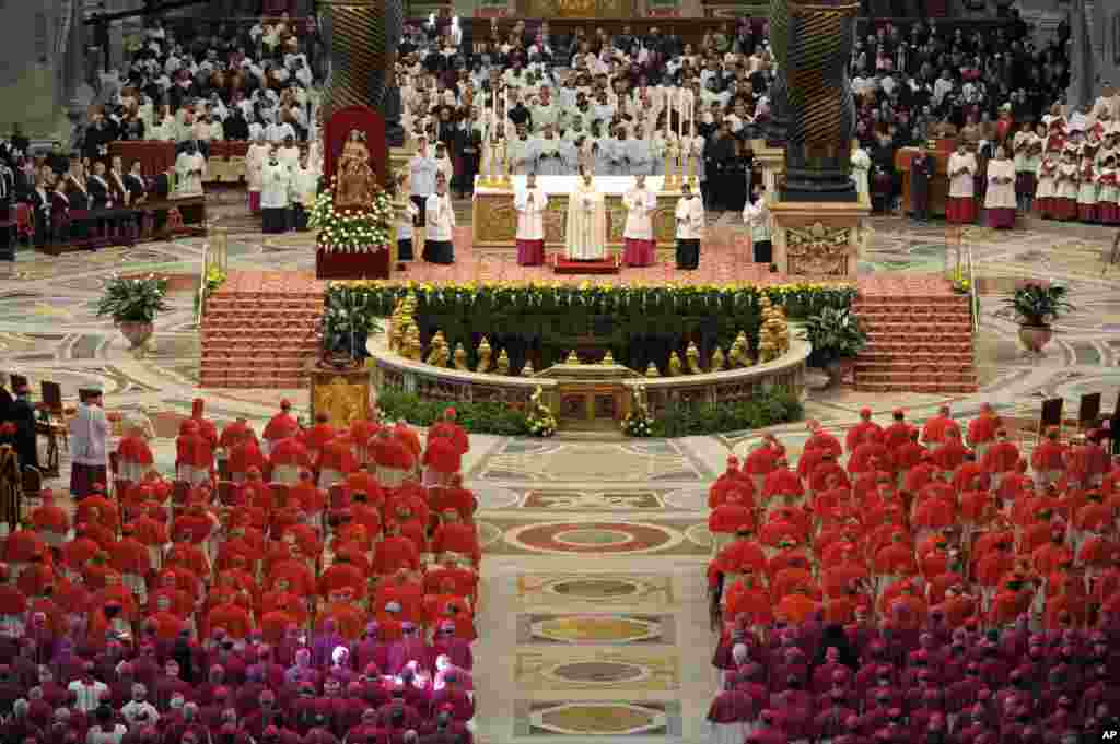 Đức Giáo Hoàng Phanxicô đứng giữa chủ trì Hội đồng Hồng Y bên trong Đại Giáo đường Thánh Phêrô tại Vatican. Cùng dự lễ tấn phong các Hồng Y với Đức Giáo Hoàng Franxicô 2 có Đức Giáo Hoàng Bênêđíctô thứ 16 đã về hưu.