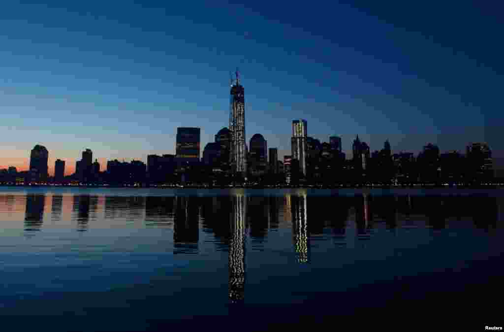 Gedung One World Trade Center di New York terpantul di Sungai Hudson, seperti terlihat dari Jersey City, New Jersey (10/5). (Reuters/Gary Hershorn)