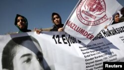 Human rights activists hold a banner with a portrait of Erdal Eren, a leftist executed during the military rule after the coup in 1980, as they demonstrate in front of a courthouse in Ankara, April 4, 2012.