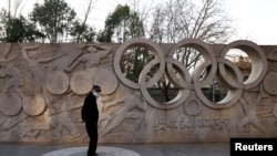 一名男子站在北京的一个树立奥林匹克圆环的公园里。（2021年12月7日）