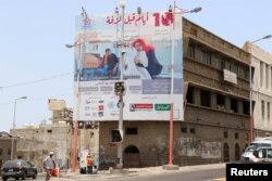 A man walks past a billboard displaying an advertisement for the local movie "10 Days Before the Wedding" in Aden, Yemen, Sept. 1, 2018.