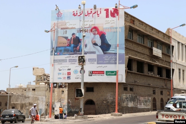 A man walks past a billboard displaying an advertisement for the local movie "10 Days Before the Wedding" in Aden, Yemen, Sept. 1, 2018.