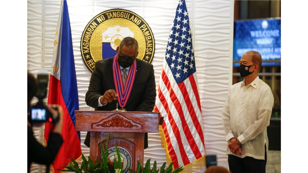 Menteri Pertahanan Amerika Serikat Lloyd Austin (kiri) menandatangani buku tamu saat Menteri Pertahanan Filipina Delfin Lorenzana (kanan) meninjau kamp militer Camp Aguinaldo di Quezon City, Metro Manila, Filipina, 30 Juli 2021. (Foto: Rolex Dela Pena via
