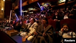 Moviegoers cheer and wave lightsabers before the first showing of the movie "Star Wars: The Force Awakens" at the TCL Chinese Theatre in Hollywood, California, Dec. 17, 2015.