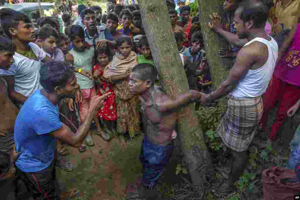 Rohingya Muslims, who recently crossed over from Myanmar into Bangladesh, interrogate a suspected child trafficker near Balukhali refugee camp, Bangladesh.