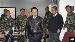 South Korean President Lee Myung-bak, center, arrives with Defense Minister Kim Tae-young, second right, in Seoul, South Korea, as the military was put on top alert after North Korea's artillery attack on the South Korean island of Yeonpyeong, 23 Nov 2010