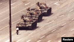 FILE - A man stands in front of a convoy of tanks in the Avenue of Eternal Peace in Beijing, China, June 5, 1989. 