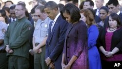 President Barack Obama, first lady Michelle Obama, and members of the White House staff observe a moment of silence to mark the 11th anniversary of the September 11, 2001 terrorist attacks on the South Lawn of the White House.