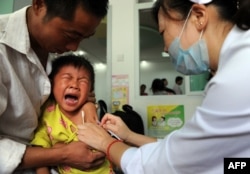 FILE - A Chinese boy screams out in pain as he gets inoculated against measles as part of a free 10-day nationwide campaign to urge parents to participate amid public fears about the safety of the inoculations in Hefei, in eastern China's Anhui province on Sept. 11, 2010.