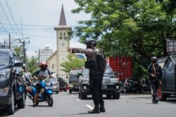 Seorang polisi mengatur lalu lintas setelah ledakan di luar sebuah gereja di Makassar pada 28 Maret 2021. (Foto: AFP/Daeng Mansur)