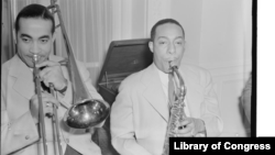 Jazz musicians Lawrence Brown and Johnny Hodges of the Duke Ellington Orchestra are shown playing together at the Turkish ambassador's residence. William P. Gottlieb/Library of Congress