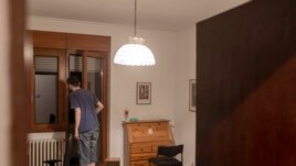 In this photo taken on Friday, July 2, 2021, Nemanja Dragic, 36,opens his door as noise from a local bar fills his apartment in Belgrade, Serbia. Serbia’s capital is alive with nightlife again after over a year of pandemic restrictions with bars and other nightlife places opening again. (AP Photo/Marko Drobnjakovic)