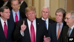 Sen. John Barrasso, R-Wyo., left, and Sen. John Thune, R-S.D., stand with President Donald Trump, Vice President Mike Pence, Sen. Roy Blunt, R-Mo., and Senate Majority Leader Mitch McConnell of Ky., as Trump speaks on Capitol Hill in Washington, Jan. 9, 2019. 