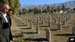 Men stand at a graveyard where the dead of 1988 gas attack on Halabja, Iraq, by Saddam Hussein's regime were laid to rest. (file)