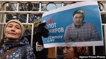A woman holds a banner with a portrait of journalist Bolot Temirov as people take part in a rally calling for a stop to the persecution of journalists and for the release of Temirov, who was detained the night before, in Bishkek, Kyrgyzstan, Jan. 23, 2022