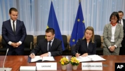Šef ukrajinske diplomatije Pavlo Klimkin i visoka predstavnica EU za spoljnu politiku Federika Mogerini potpisuju sporazumu o statusu Savetodavne misije EU za reformu sektora civilne bezbednosti u Briselu, 17. novembra 2014.