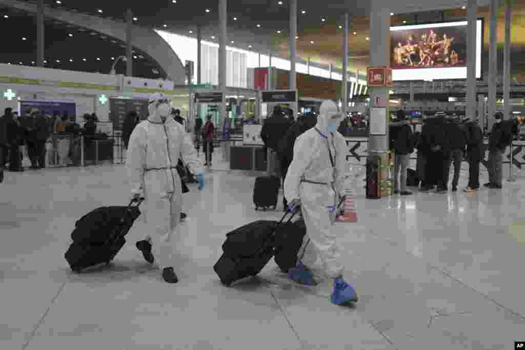 Passengers from Taiwan wearing protective gear arrive to board their plane at Paris Charles de Gaulle Airport in Roissy, north of Paris, France.