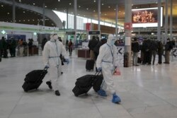 Para penumpang dari Taiwan mengenakan baju pelindung saat tiba di Bandara Paris Charles de Gaulle di Roissy, utara Paris, 1 Februari 2021. (Foto: Reuters)