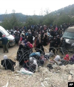 Syrians wait to enter Turkey at the Bab al-Salam border gate, Syria, Feb. 3, 2016. Turkish officials say thousands of Syrians have massed on the Syrian side of the border seeking refuge in Turkey.