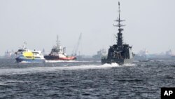 The Republic of Singapore Navy's RSS Brave, right, sails off from the Tuas naval base on a search-and-rescue mission for the USS John S. McCain's missing sailors, Aug. 24, 2017, in Singapore.