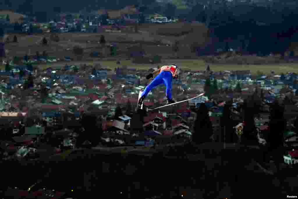 Atlet sky Austria Manuel Fettner melayang di udara dalam putaran percobaan Turnamen Ski Jumping Four Hills di Oberstdorf, Jerman.