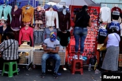 A migrant from Venezuela, sells clothing at Gamarra textile cluster in Lima's district of La Victoria in Lima, Peru, May 10, 2018.