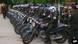 FILE PHOTO - Cambodian military police officers stand by with their motorcycles at Stung Meanchey where Prime Minister Hun Sen made his first public appearance since Sunday's election, in Phnom Penh, Cambodia, Wednesday, July 31, 2013. (AP Photo/Heng Sinith)