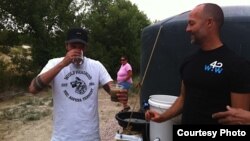 Jon Rose drinks freshly-filtered rain water from a rain catchment system. (Courtesy Waves for Water) 