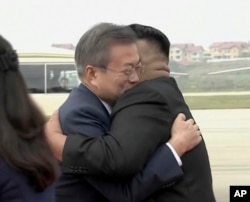 Image made from video provided by Korea Broadcasting System (KBS), South Korean President Moon Jae-in (L) hugs North Korean leader Kim Jong Un upon arrival in Pyongyang, North Korea, Sept. 18, 2018.