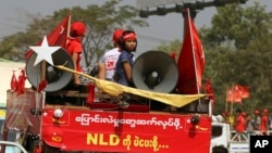 Supporters of Myanmar ruling National League for Democracy party ride on a truck displaying banner that reads: "To continue change, let's vote NLD" during a campaign for the upcoming by-election, March 19, 2017, in the outskirts of Yangon, Myanmar.