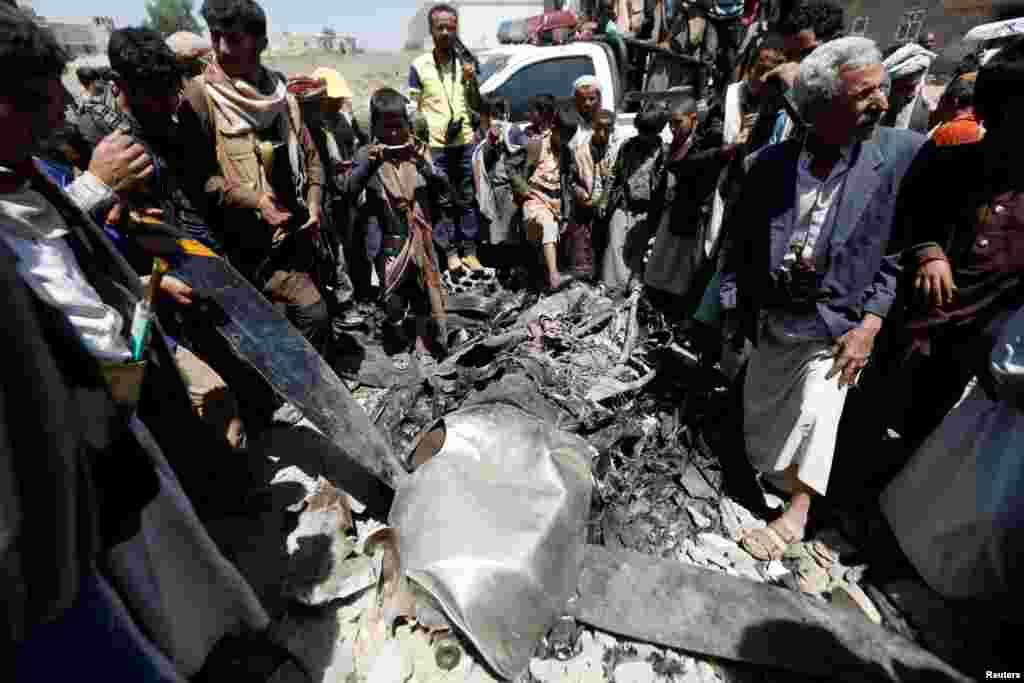 People gather around the engine of a drone aircraft which the Houthi rebels said they have downed in Sana&#39;a, Yemen.