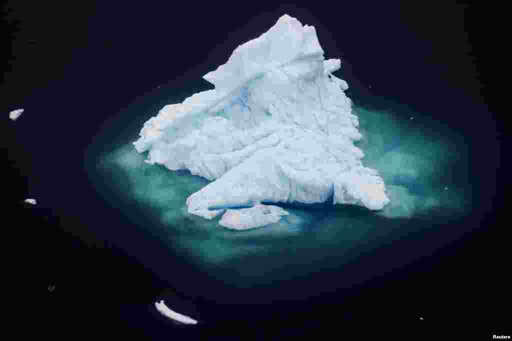 An iceberg floats in a fjord near the town of Tasiilaq, Greenland, in this photo taken June 24, 2018. A team of NASA scientists traveled to Greenland to study exactly how warming oceans are melting the island&#39;s ice.