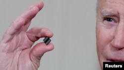 资料照片：美国总统拜登在白宫介绍美国半导体产业面临的挑战时手中拿着一个芯片（2021年2月24日）