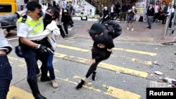 A still image from a social media video shows a protester try to prevent a police officer from aiming his gun at a protester in Sai Wan Ho, Hong Kong, China November 11, 2019. 