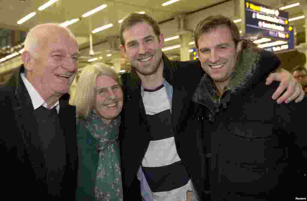 Video cameraman Kieron Bryan (2nd R) poses for a photograph with his mother Ann (2nd L), father Andy (L) and brother Russel after arriving at St. Pancras station in central London, England, Dec. 27, 2013. 