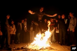 An Iranian man jumps over a bonfire during a celebration, known as "Chaharshanbe Souri," or Wednesday Feast, marking the eve of the last Wednesday of the solar Persian year, March 19, 2019 in Tehran.