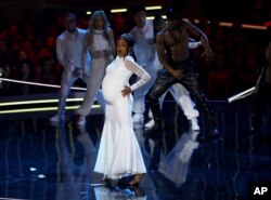 In this Saturday, June 16, 2018, photo, Tiffany Haddish performs a rendition of "Bodak Yellow" at the start of the MTV Movie and TV Awards at the Barker Hangar in Santa Monica, Calif.