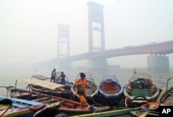 Jembatan Ampera di Sungai Musi yang diselimuti kabut asap akibat kebakaran hutan di Palembang, Sumatera Selatan. (Foto: AP)