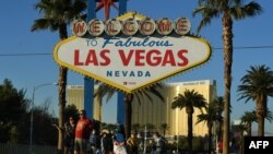 Les touristes devant un signe de bienvenue, à l'hôtel Mandalay à Las Vegas, Nevada, le 15 novembre 2017.