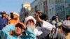 People look up at a dead body hanged by the Taliban from a crane in the main square of Herat city in western Afghanistan, on Sept. 25, 2021. 