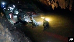 In this handout photo released by Tham Luang Rescue Operation Center, Thai rescue teams walk inside a cave complex where 12 boys and their soccer coach went missing, in Mae Sai, Chiang Rai province, in northern Thailand, July 2, 2018.