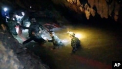 In this handout photo released by Tham Luang Rescue Operation Center, Thai rescue teams walk inside a cave complex where 12 boys and their soccer coach went missing, in Mae Sai, Chiang Rai province, in northern Thailand, July 2, 2018.
