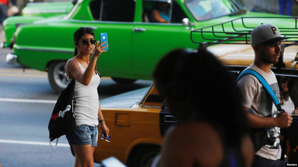 Una mujer usa Internet en su telÃ©fono mÃ³vil en un punto de acceso en La Habana, Cuba, el 10 de julio de 2018.
