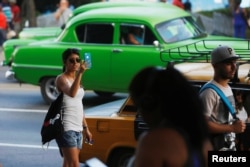 A woman uses the internet on her mobile phone at a hotspot in Havana, Cuba, July 10, 2018.