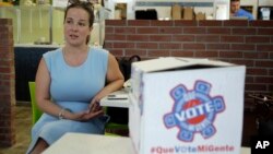 FILE - Christina Hernandez, an official with Organize Now, spends time at the Valisa Bakery to register voters in Orlando, Fla., Oct. 4, 2016. Organize Now is a progressive, grassroots nonprofit that is part of a coalition of groups working on registering