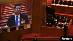 北京人大会堂举行的全国人大年度会议大屏幕上显示中国领导人习近平在出席会议。（2021年3月8日）