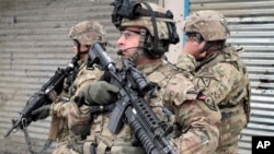 U.S. soldiers stand guard at the scene of a suicide attack in Kabul, Afghanistan, Feb. 27, 2013.