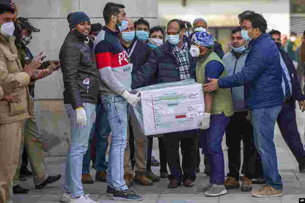 Health workers shift a box containing COVID-19 vaccine from a vehicle to a cold storage at Rajiv Gandhi Super Speciality hospital in New Delhi, India.