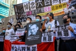 壹传媒集团创办人黎智英（左三）和香港支联会成员以及支持者在西九龙法院应讯前手举刘晓波遗像和悼念六四无罪的牌子呼喊口号。（2020年7月13日）（2020年7月13日）